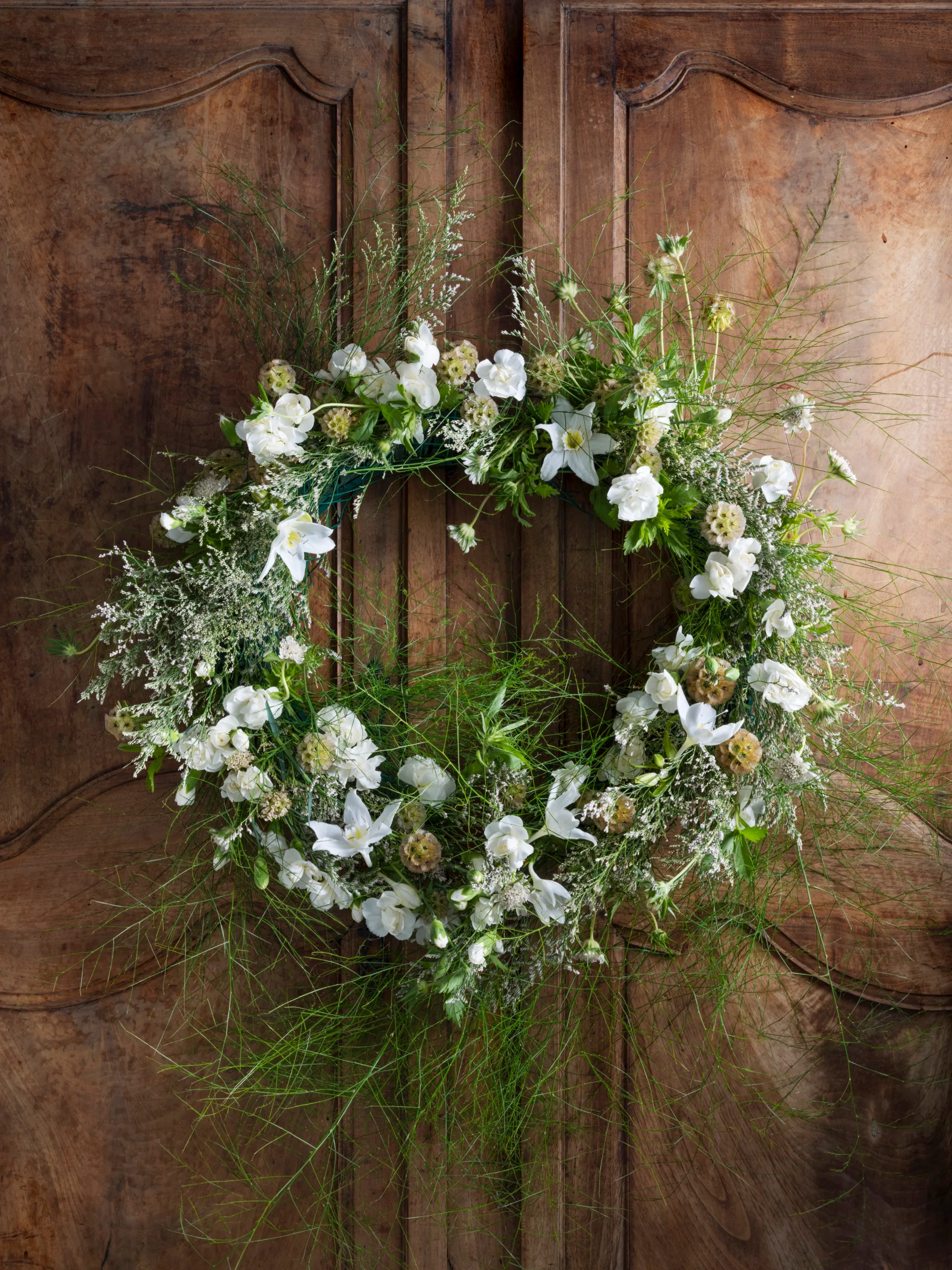 A cottage style Christmas wreath with lilies.