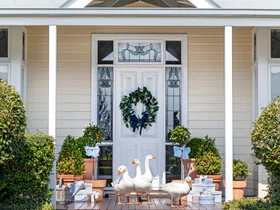 The outdoor white Hamptons style entrance with geese on the steps.