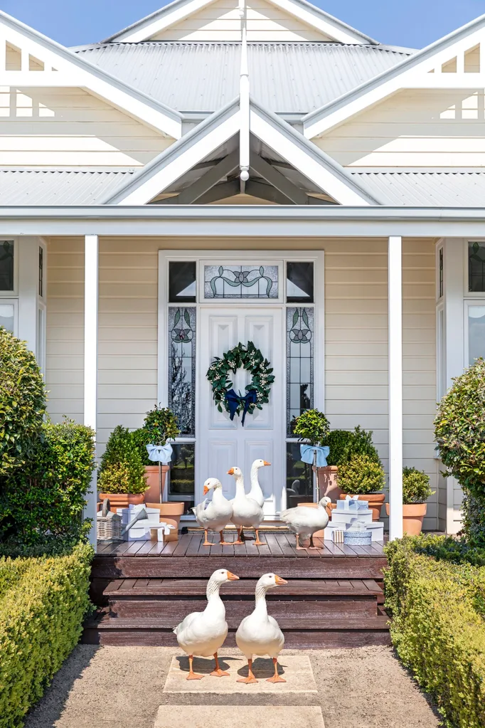 The outdoor white Hamptons style entrance with pet geese on the steps.
