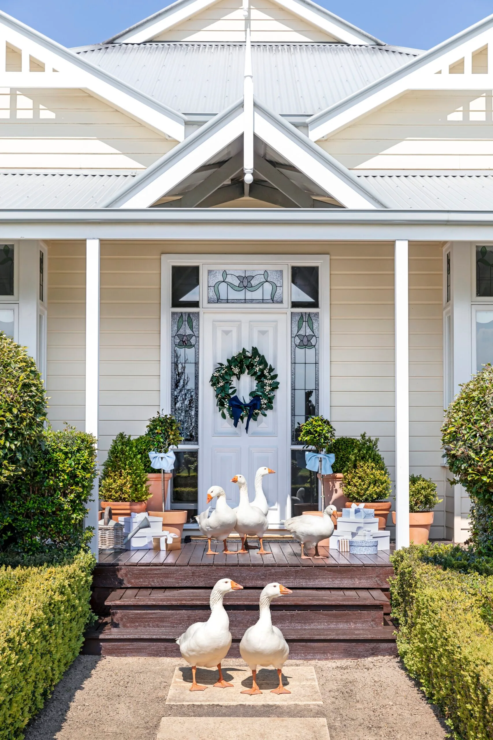 The outdoor white Hamptons style entrance with pet geese on the steps.