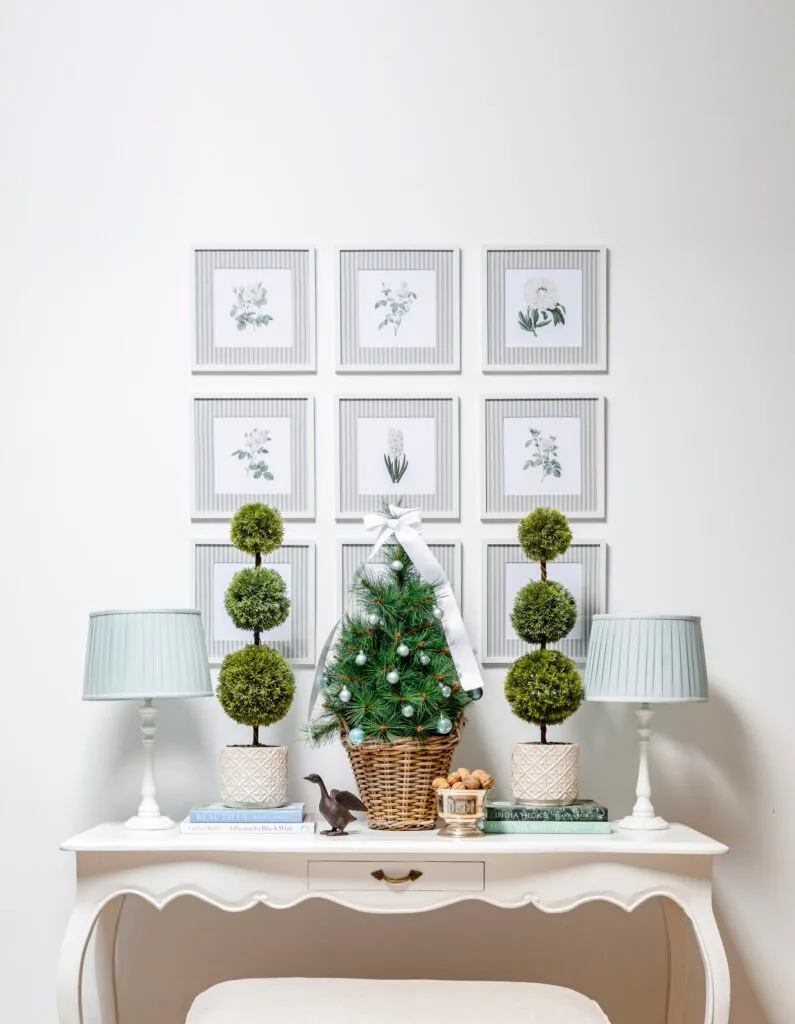 The family room with a vintage style white table adorned with a Christmas tree and mini plants.