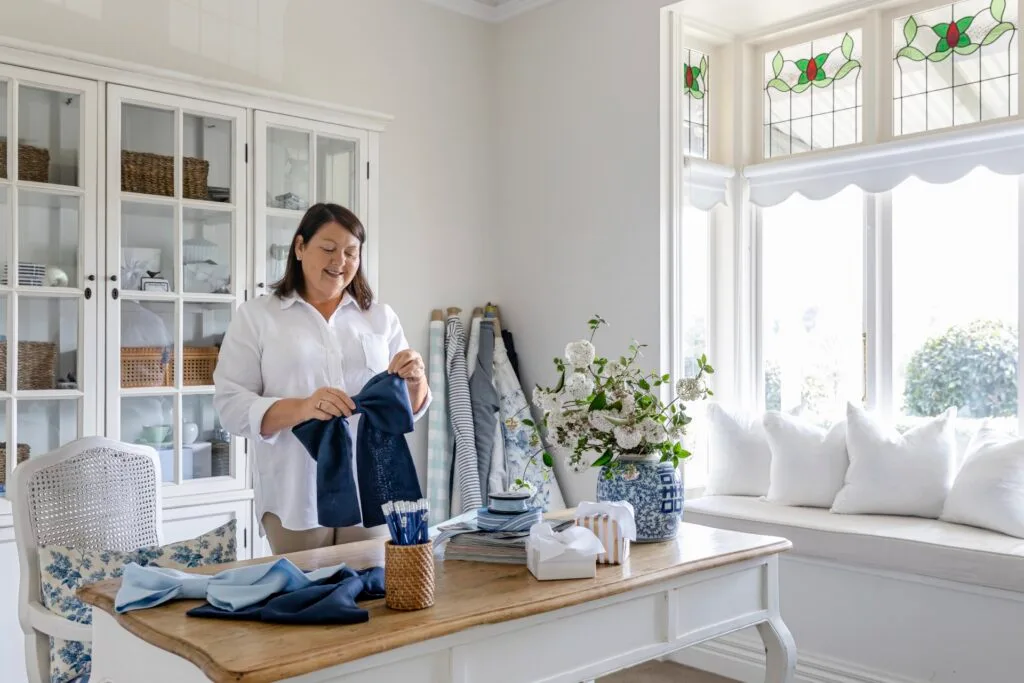 Samantha in her Hamptons style home office with white and timber furniture.