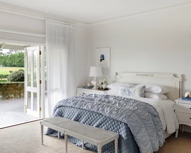 The main bedroom with French doors and classic white and blue furniture.