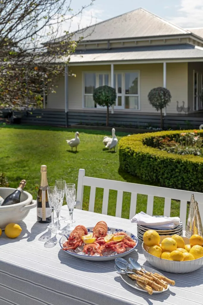 An outdoor dining table with geese in the background.