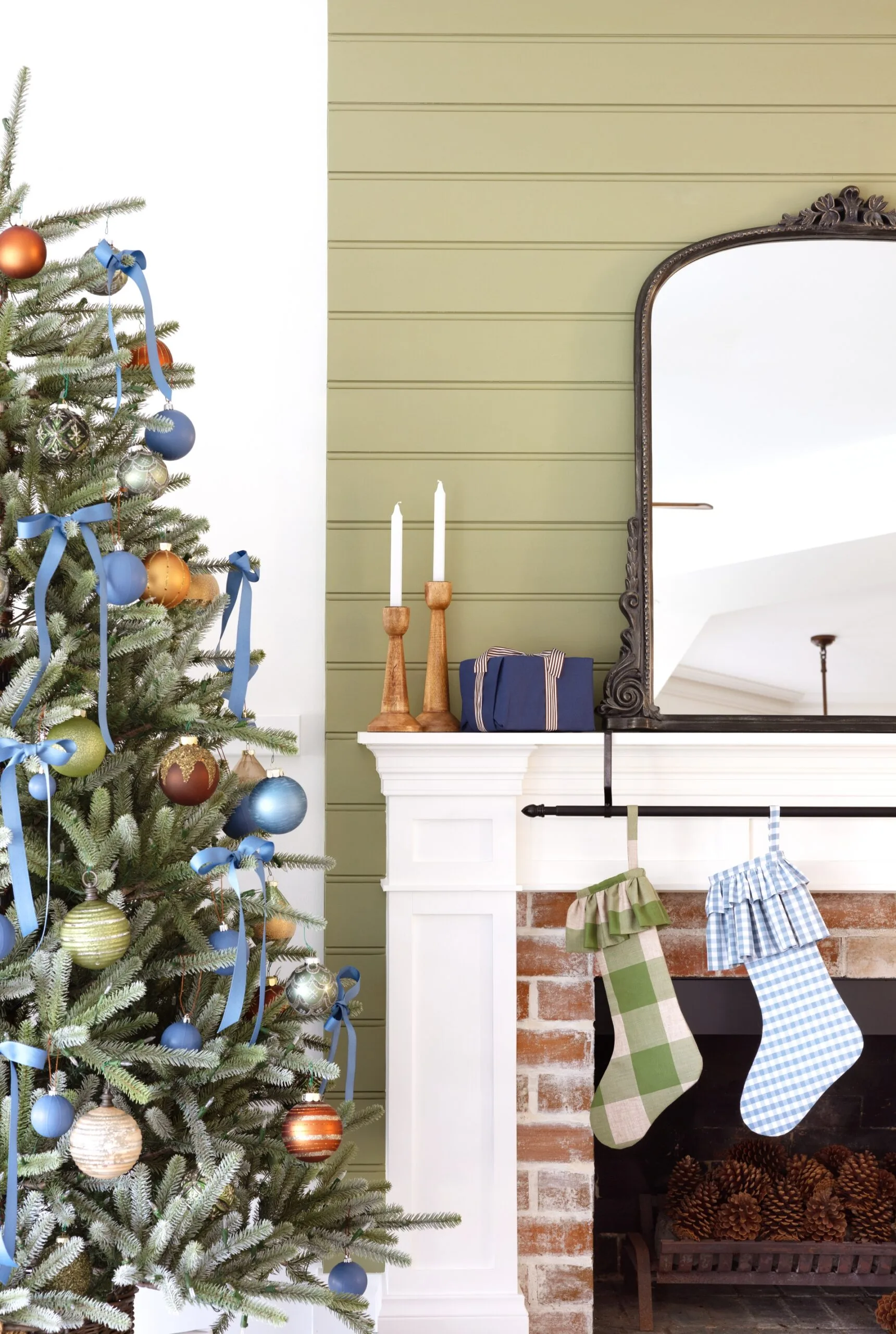 Christmas stockings on a fireplace by a decorated tree.