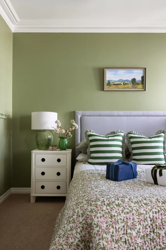 A children's bedroom with light green walls and green patterned furnishings.