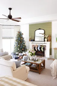 A classic living area with green accents and a Christmas tree.