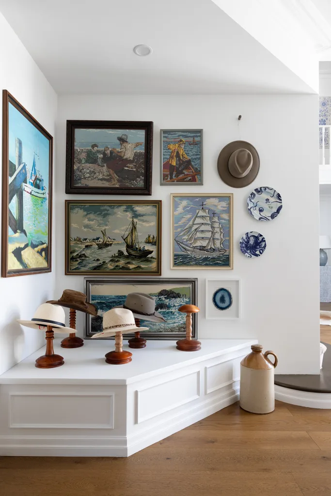 Classic vintage artworks and hats displayed in a decorative alcove.