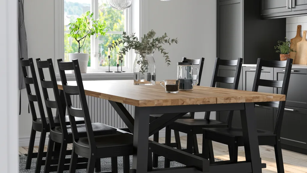 A black and natural wood dining table from Ikea with a coffee pot.