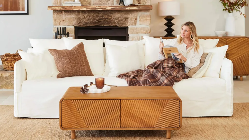 A woman lounging on a white sofa from Lounge Lovers reading a book.