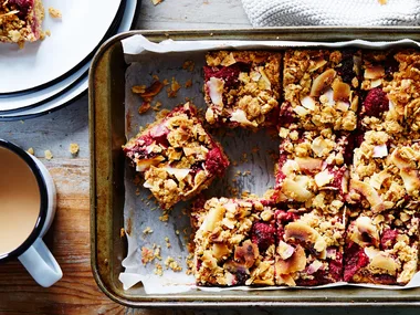 oat slice recipe in a tray with a cup of tea beside it