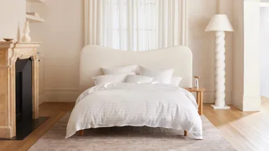 Contemporary bedroom with neutral colour palette and white quilt with striped detailing