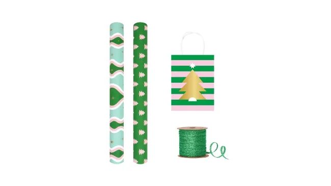 Festive gift wrap set with decorative paper rolls, green ribbon, and a pink-striped bag featuring a golden Christmas tree.