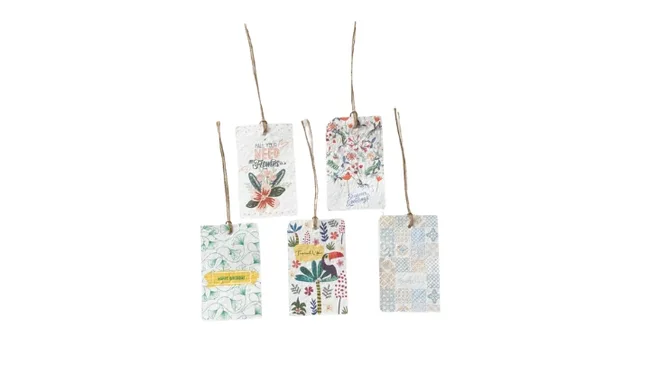 Five decorative paper tags with floral and leafy designs, hanging by strings.