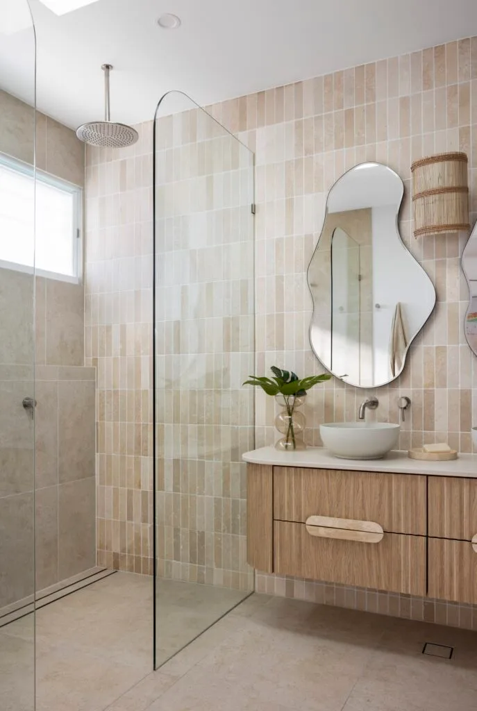 An ensuite with a walk-in shower and fluted timber vanity.