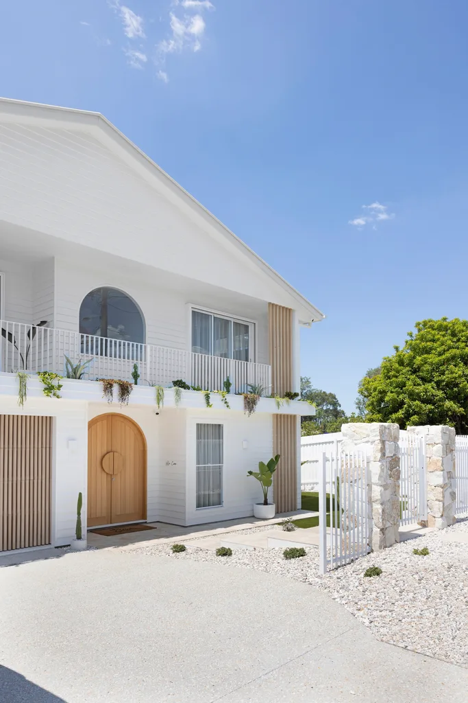 A Bali-style villa with a white facade and hanging garden.