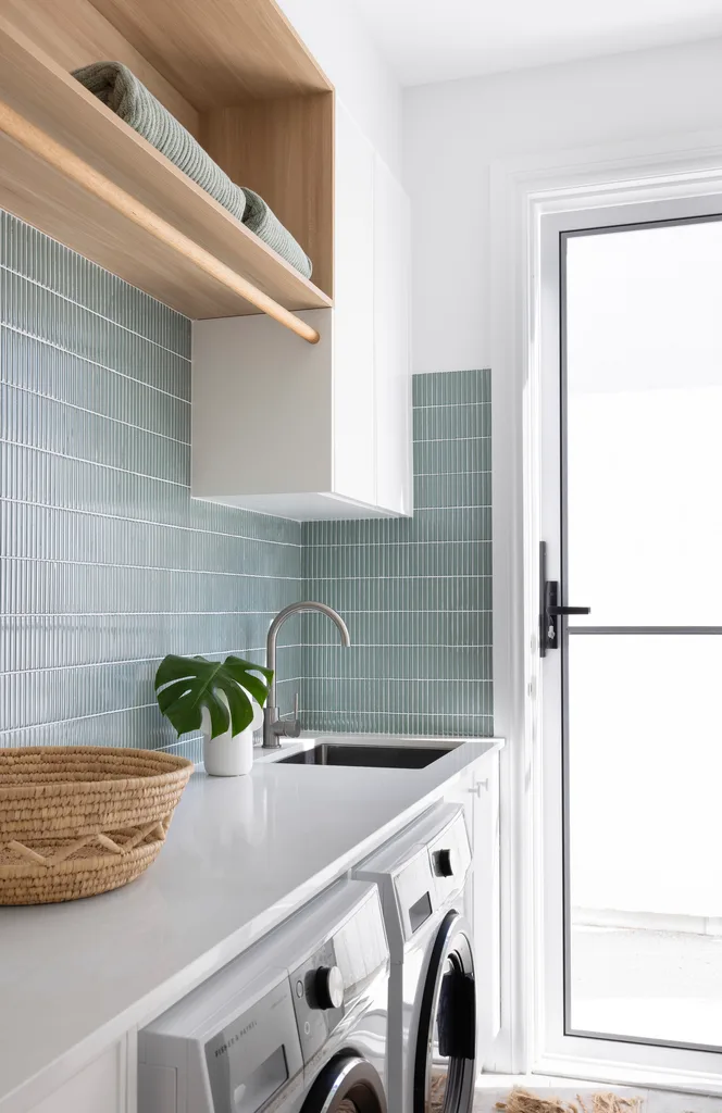 A modern laundry with a blue finger tile splashback.