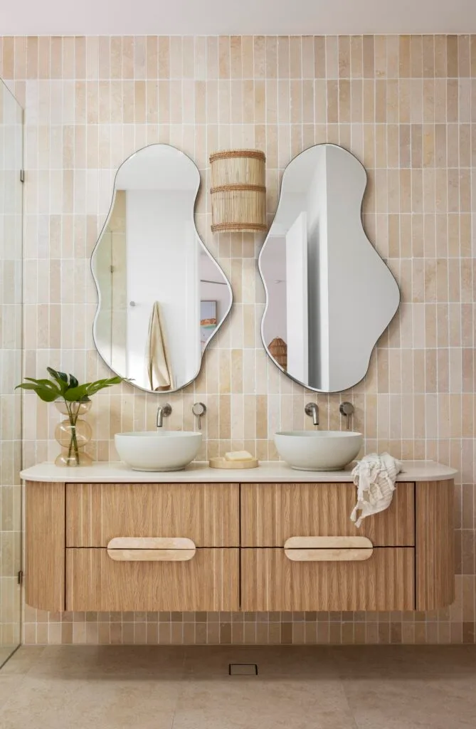 An ensuite with a fluted timber vanity and stone subway tiles.