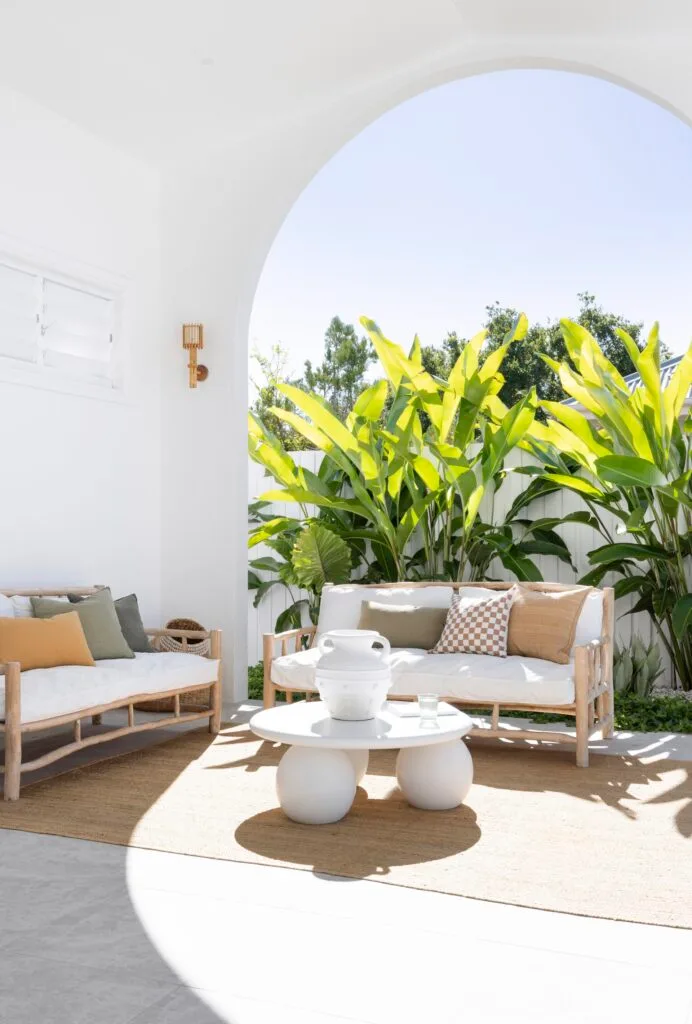 An outdoor dining and alfresco area with a white open archway.