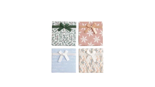 Four square gift boxes with decorative wrapping: green with foliage, pink with snowflakes, blue with script, and beige pattern.