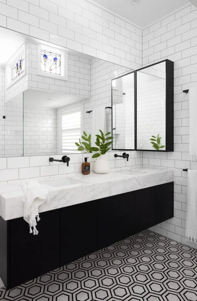 An ensuite with a black oak and white marble topped vanity.