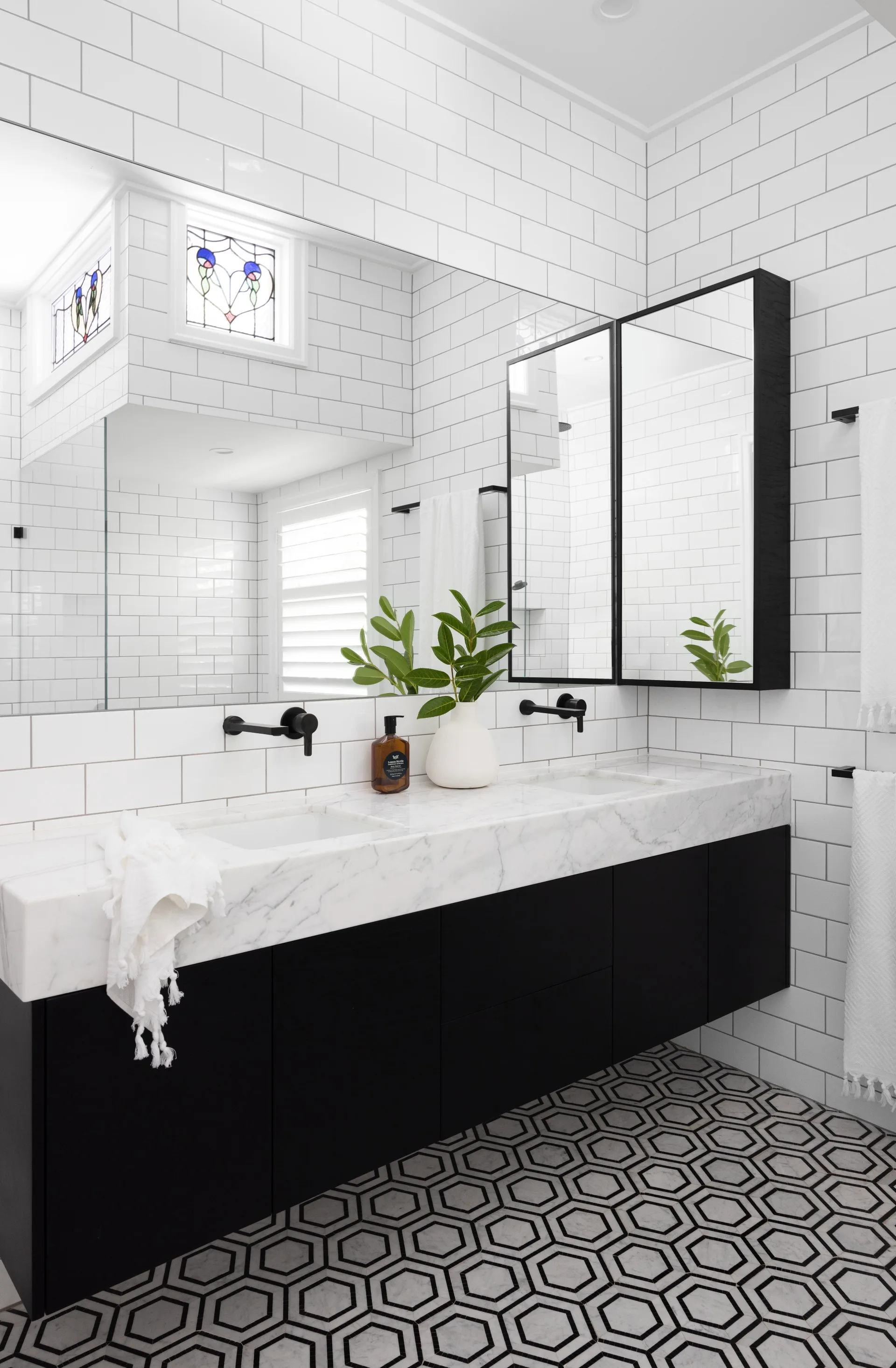 An ensuite with a black oak and white marble topped vanity.