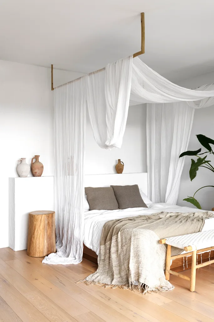 The main bedroom with a white curtained bed canopy.