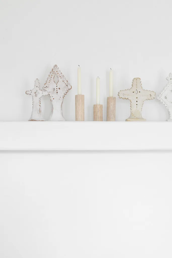 Handmade white ceramic statues on a shelf.