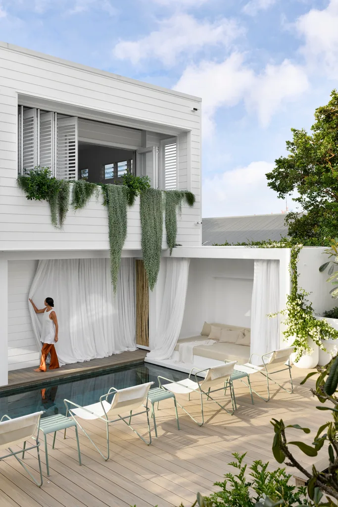 The outdoor pool area with draping plants and deck chairs.