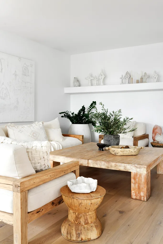 A white living room with natural timber furniture and ceramic décor.