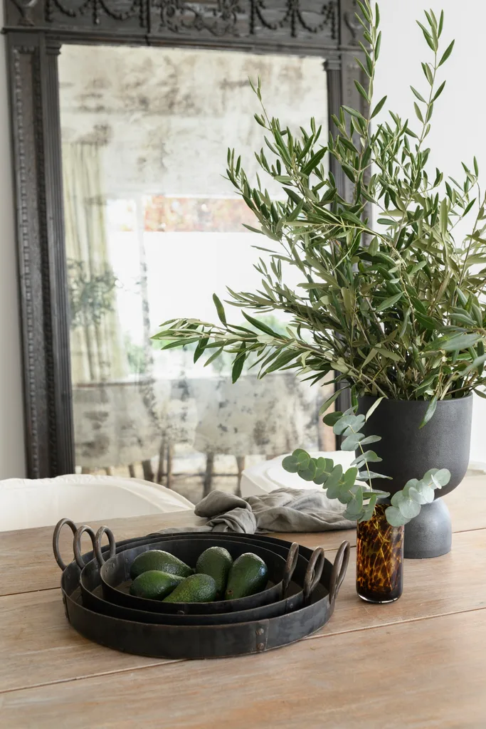 A timber dining table with a collection of rustic trays.