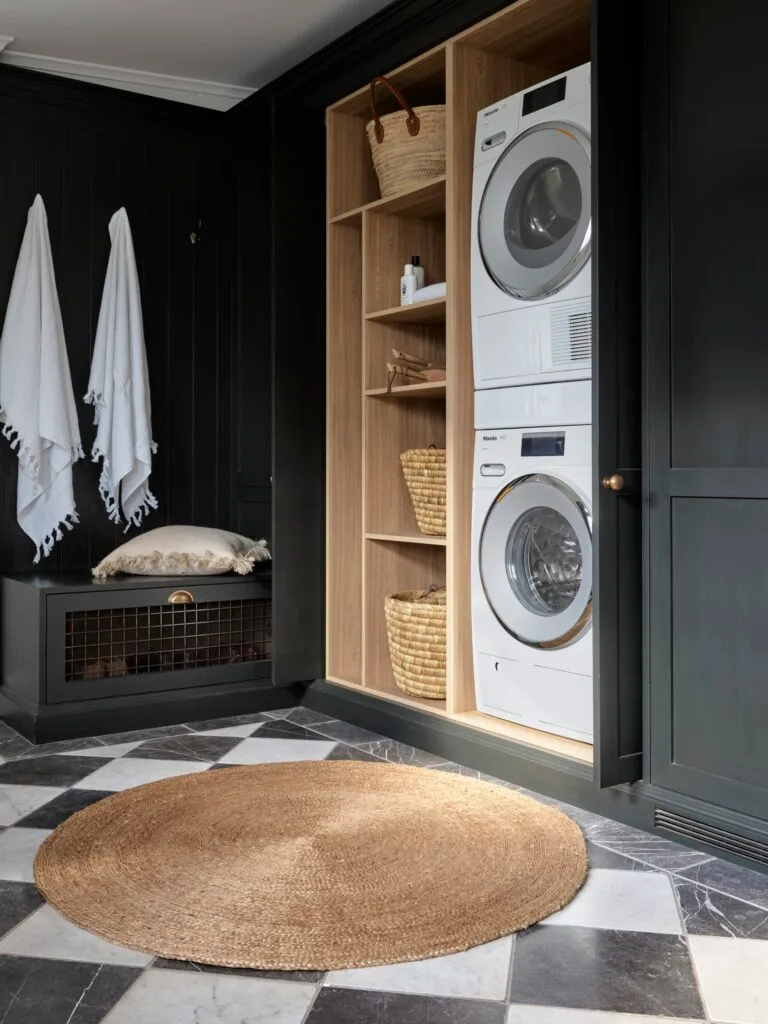 Laundry with checked flooring and black storage cupboards.