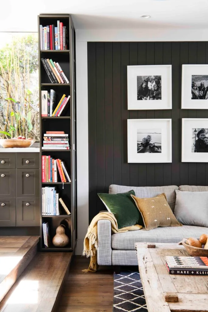 Living room with black vertical detailing and bookshelf.