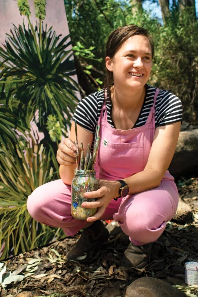 Australian artist Emily Raubenheimer with her painting in the bush.