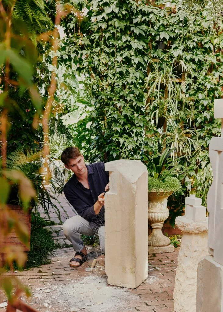 Artist Lucas Wearne carving a limestone sculpture.