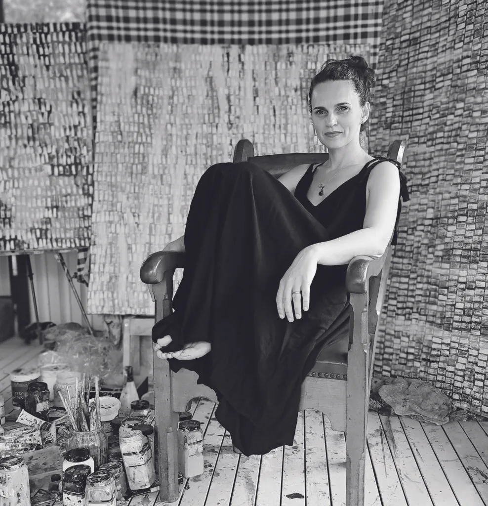 A black and white portrait of Natalie Uhrik in her studio.