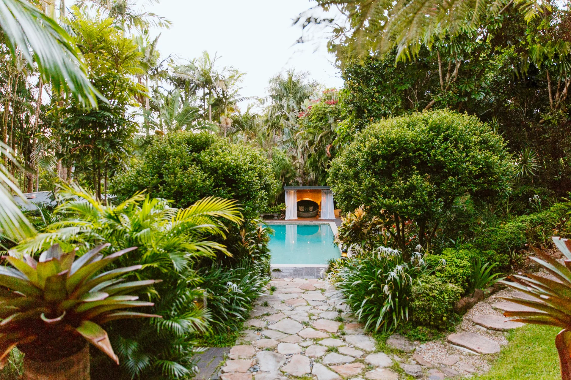 A stone path leading to a pool and cabana, Byron Bay.