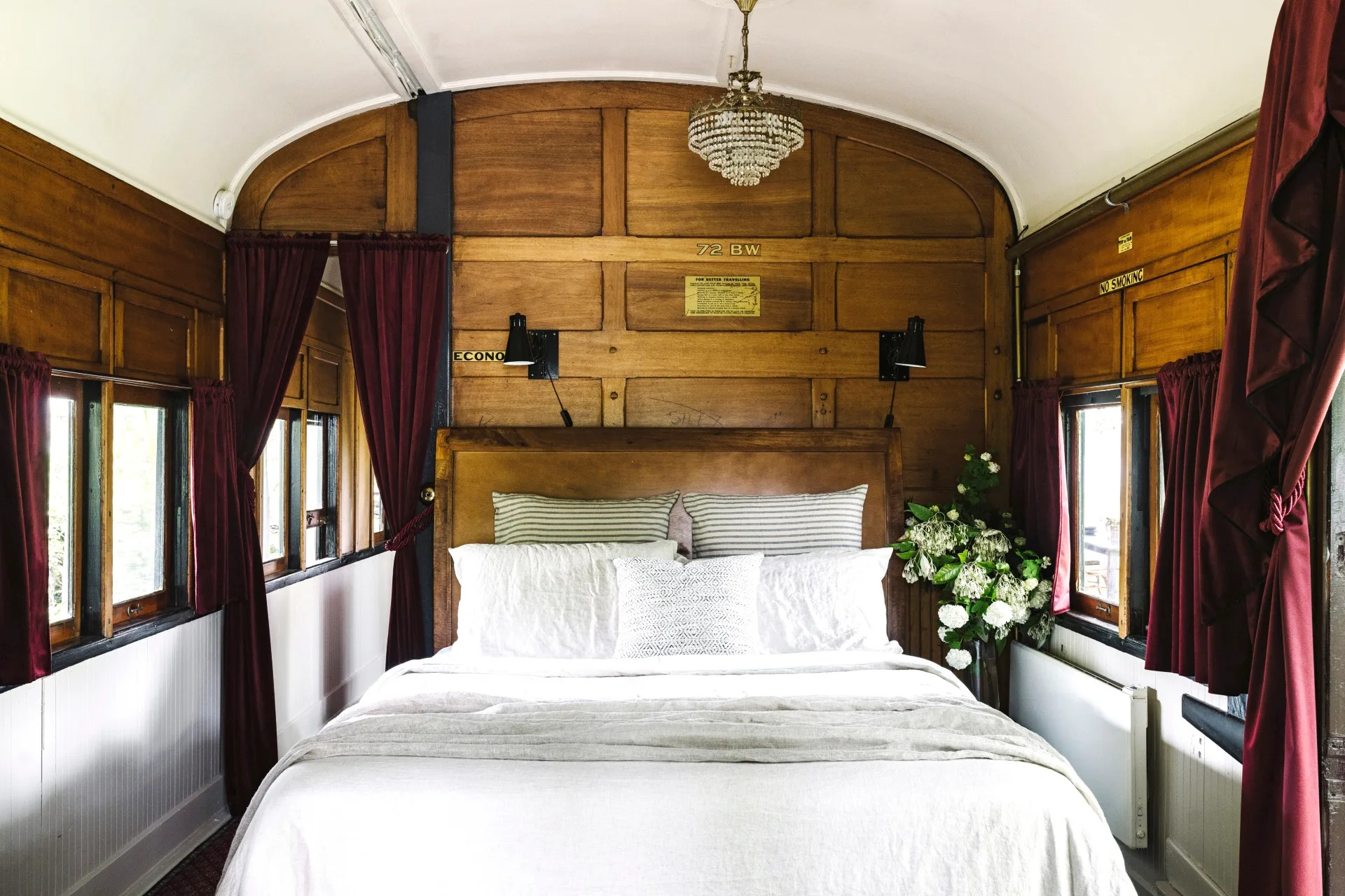 A rustic timber train carriage with a double bed.