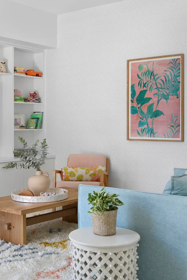 The kid's playroom with pastel blue and pink chairs and a tropical artwork.