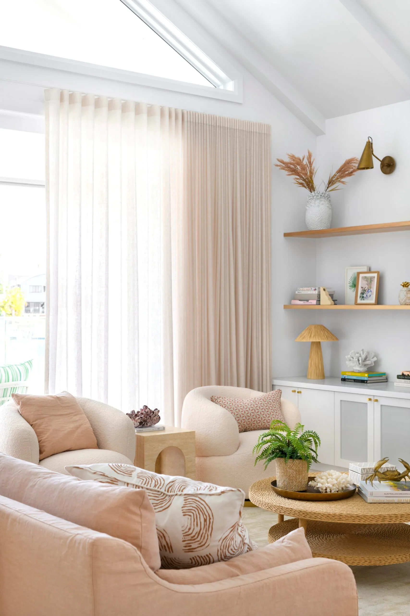 A pink pastel living area with sheer blush coloured curtains