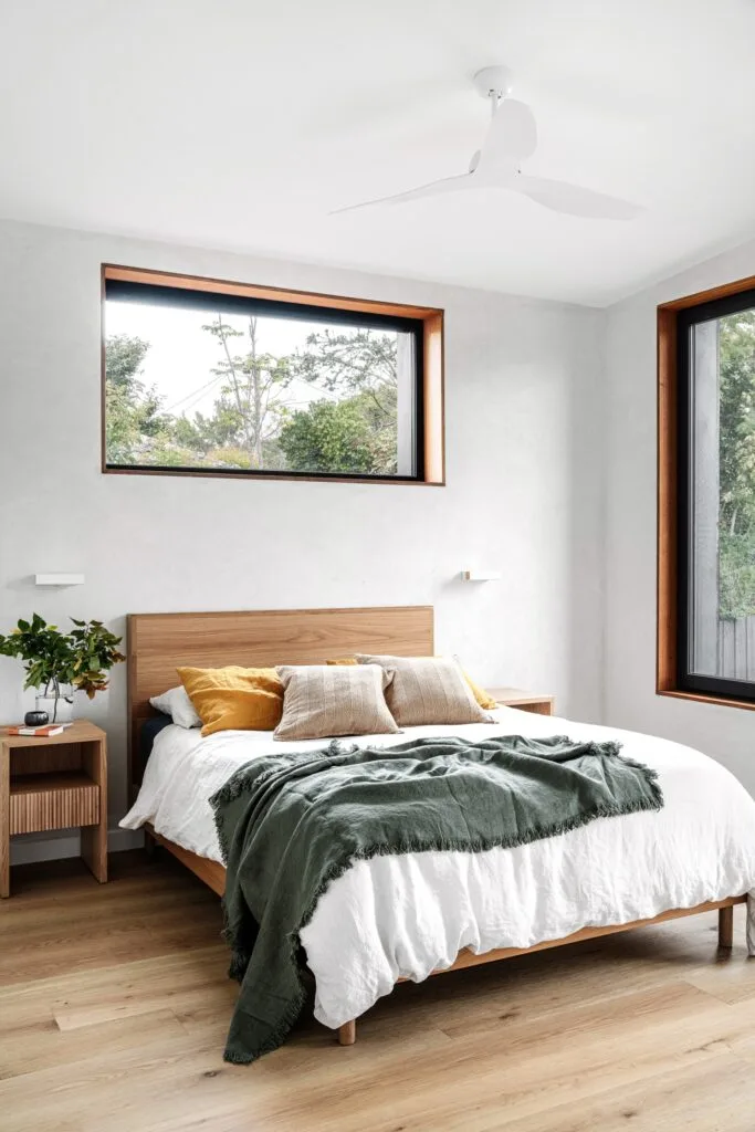 A natural white and timber bedroom with oak flooring.