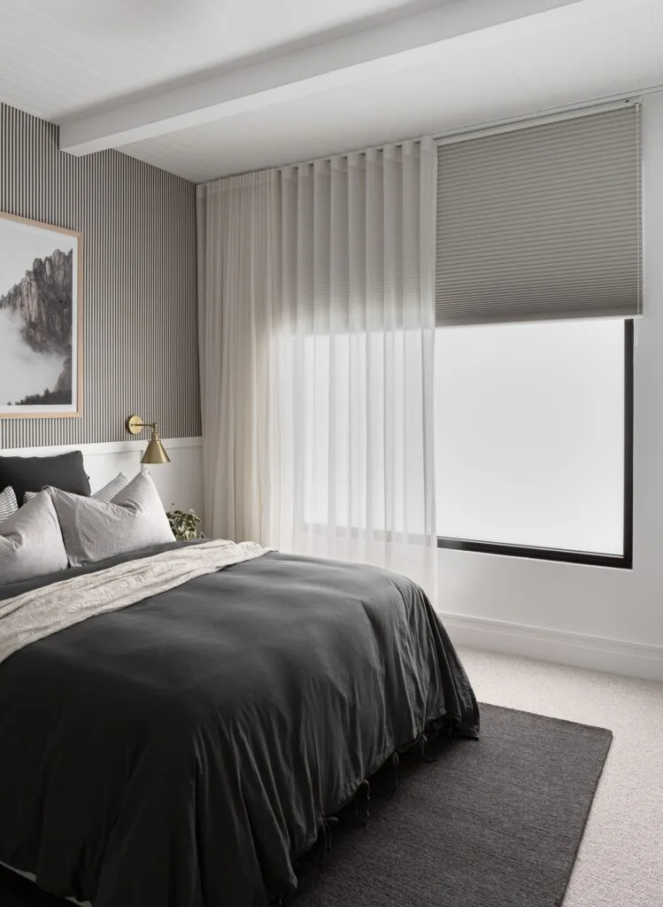 Contemporary neutral bedroom with sheer curtains.