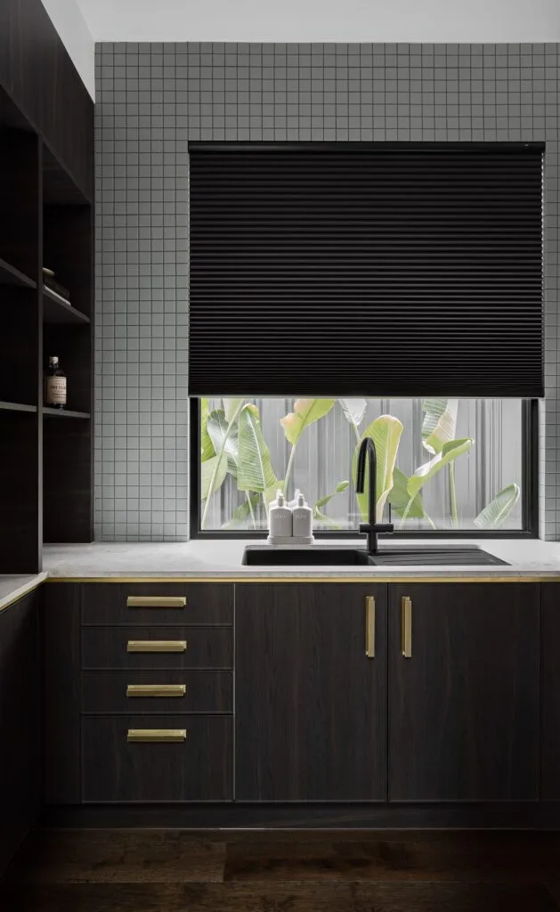 Japandi style kitchen with dark oak cabinetry and gold accents.