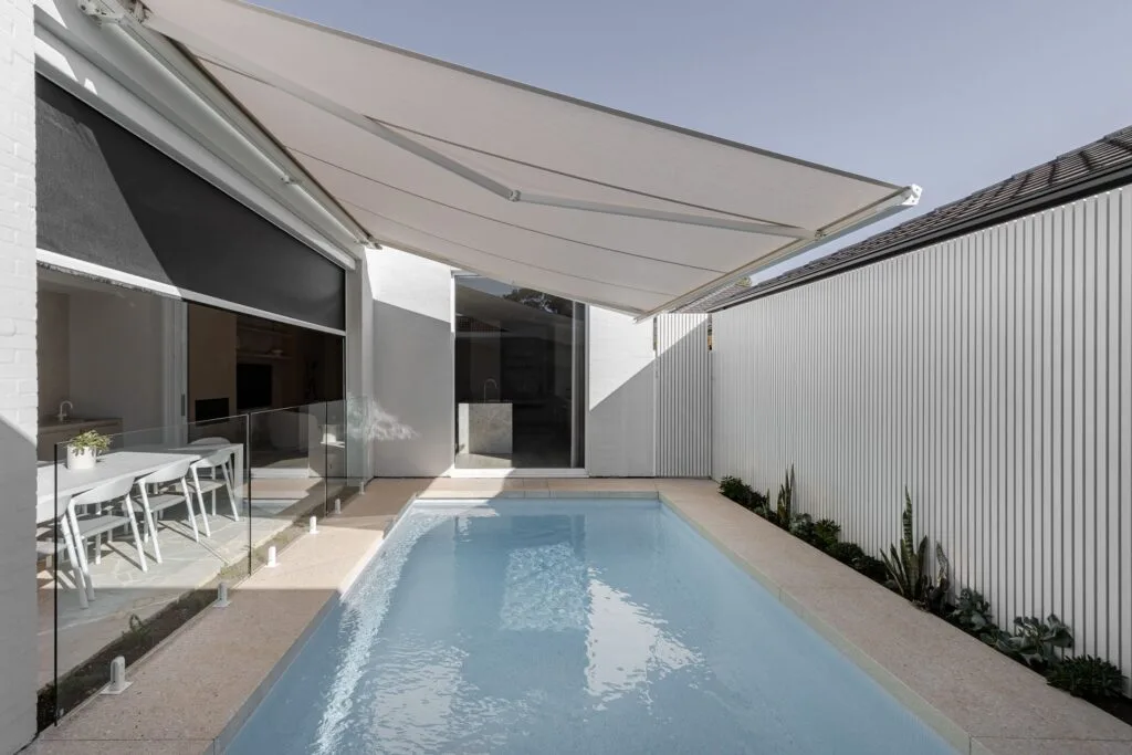 Modern outdoor pool with overhanging shade cloth.