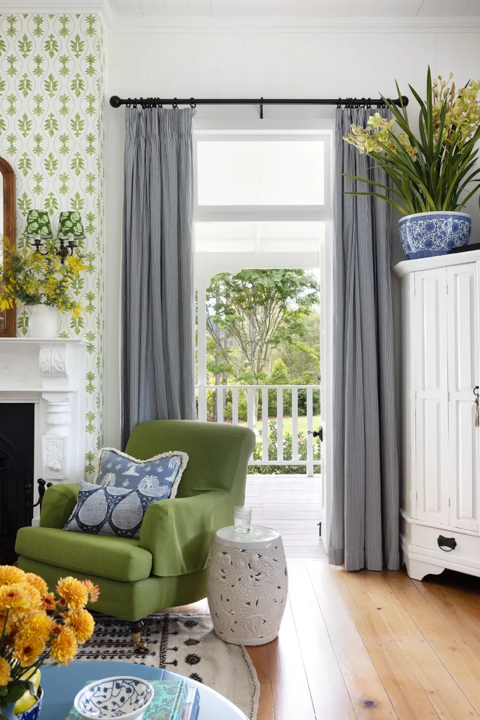Vintage-style living area with green patterned wallpaper and bright decor.
