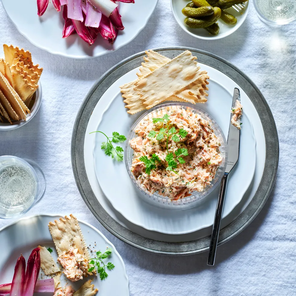 A side serving of salmon rillette with crackers.