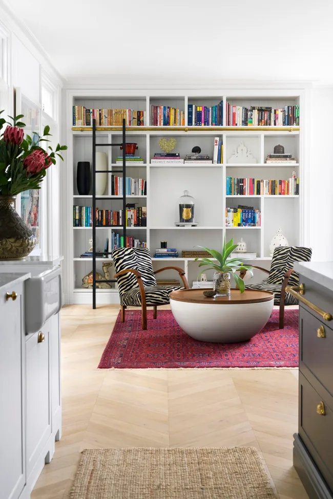 A book nook with zebra armchairs and a round table.