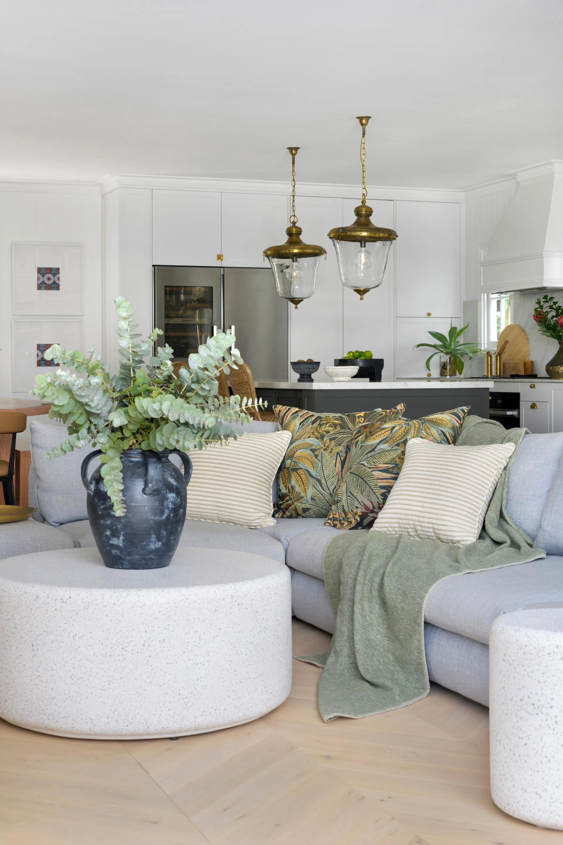 A white living area with a grey sofa and round coffee table.