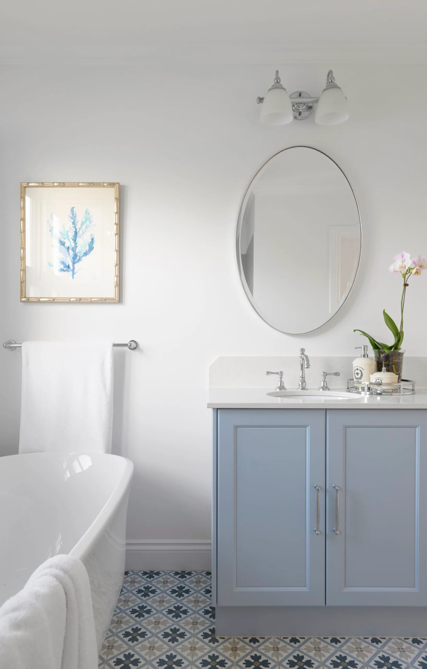 An ensuite with a baby blue vanity, Spanish tiles and freestanding bath.