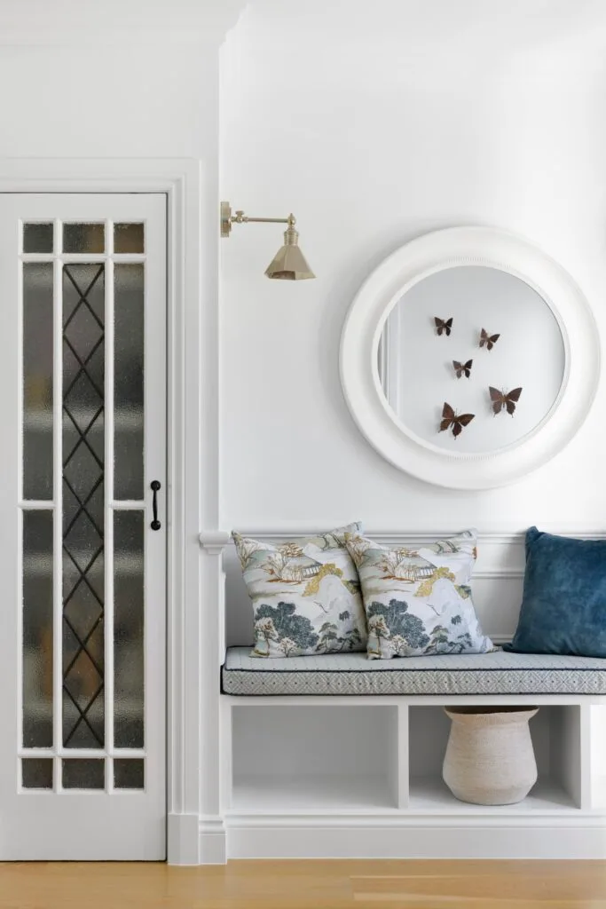 A white entry foyer with a built-in banquette.